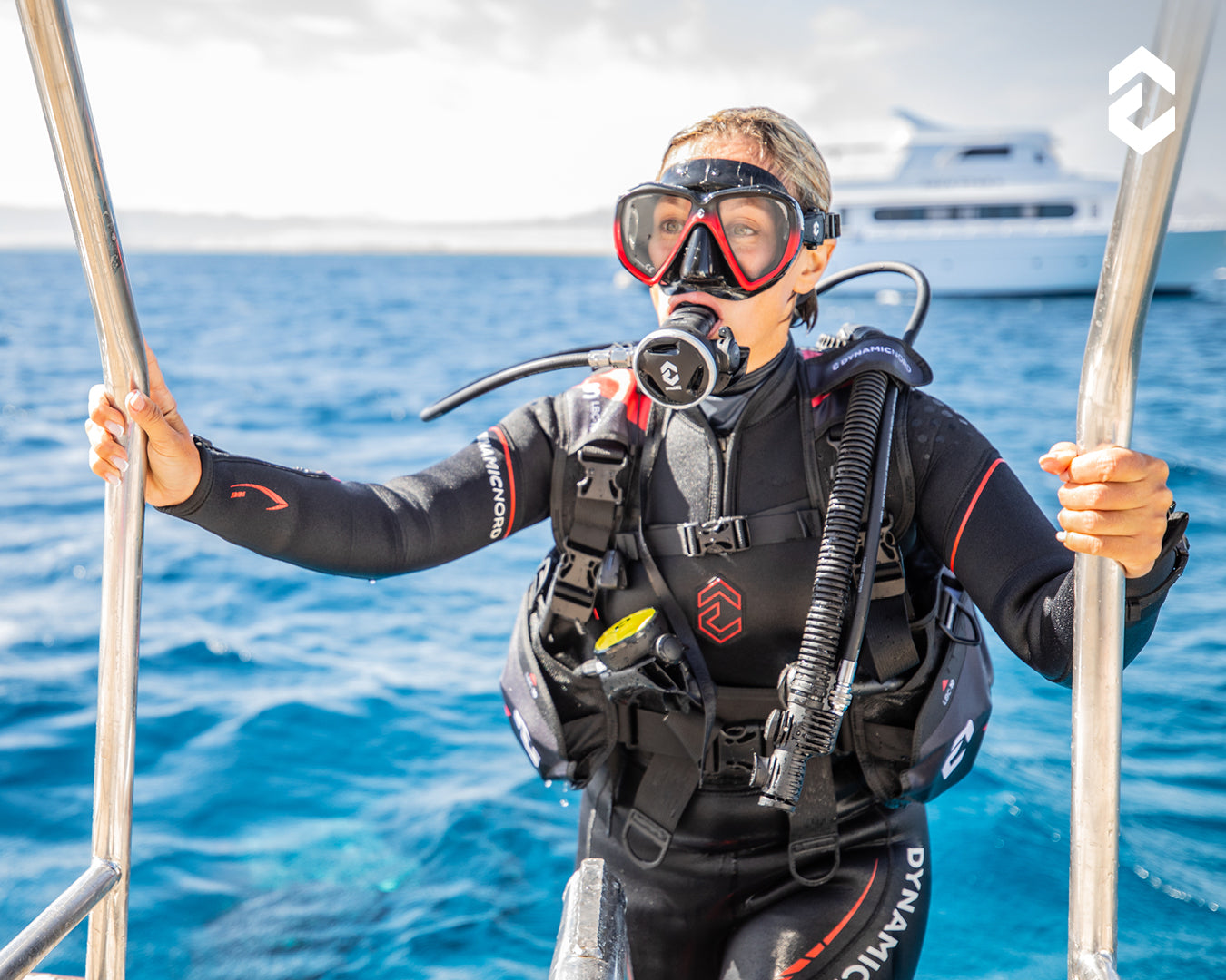 Person in scuba diving gear on a boat with water and sky in the background